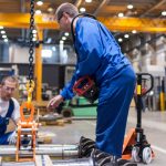 The Image Featuring Two People Analysing A Machinery In An Industrial Unit